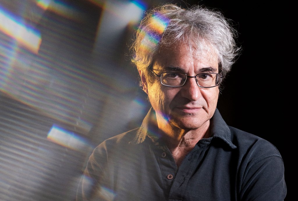 Carlo Rovelli in black tshirt and black background